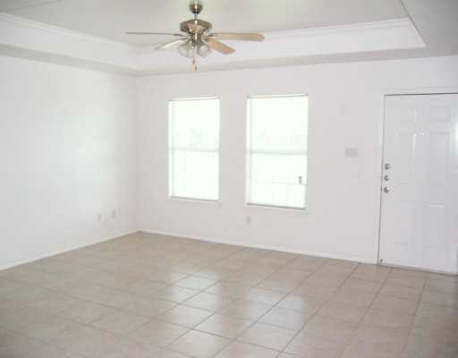 309 Easy Street, Unit A Corpus Christi, TX 78418 - Photo 2 of 8 an empty room with windows and fan