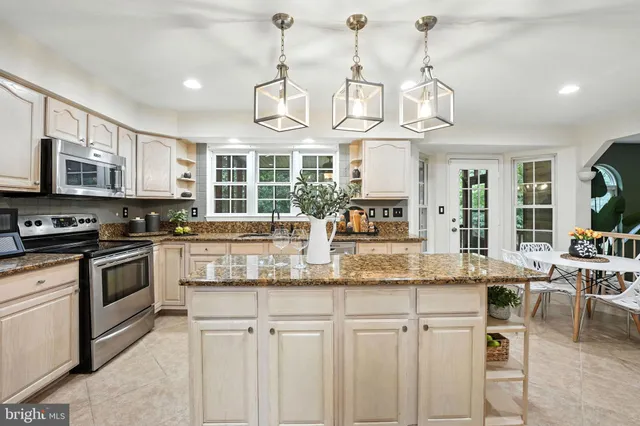a kitchen with stainless steel appliances granite countertop a stove and cabinets