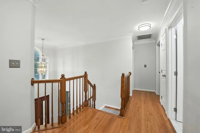 a spacious bedroom with a bed and wooden floor
