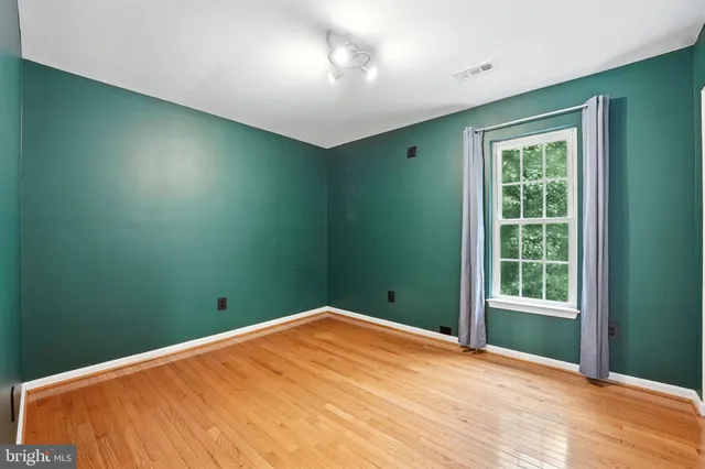 a view of empty room with wooden floor and fireplace