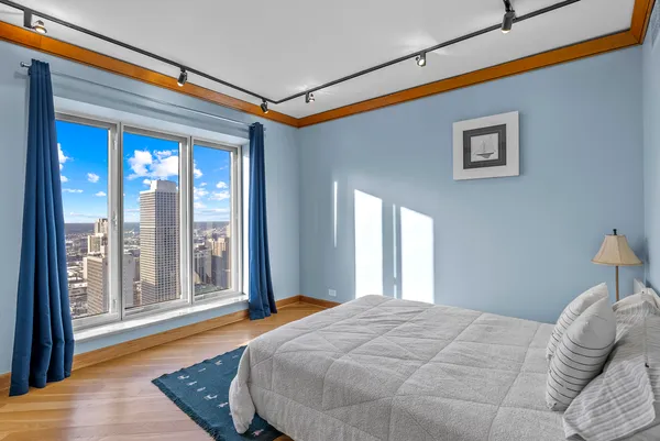 a bedroom with a bed and a large window with outer view