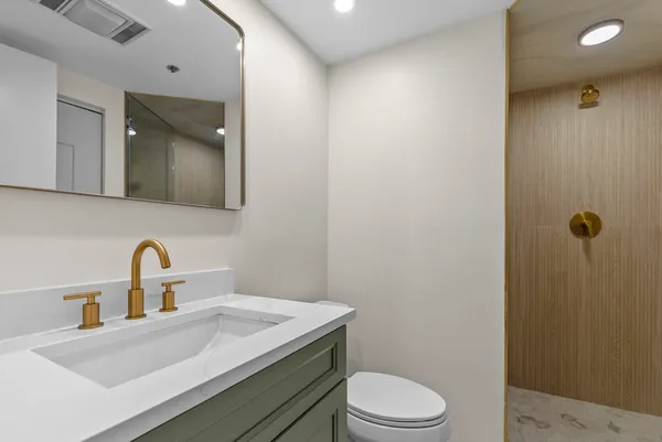 a bathroom with a sink a toilet and mirror