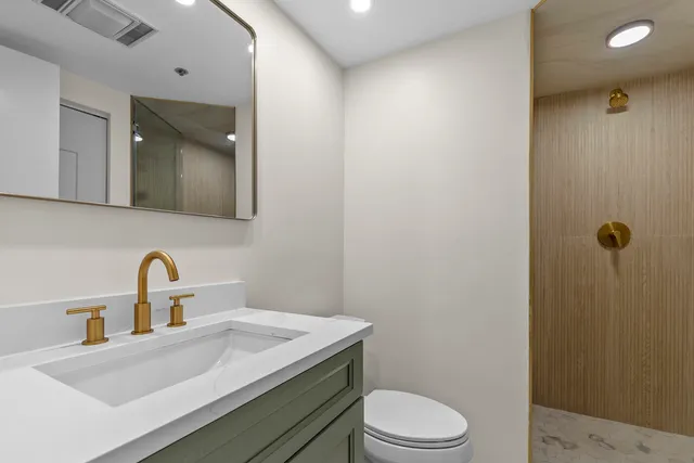 a bathroom with a sink a toilet and mirror