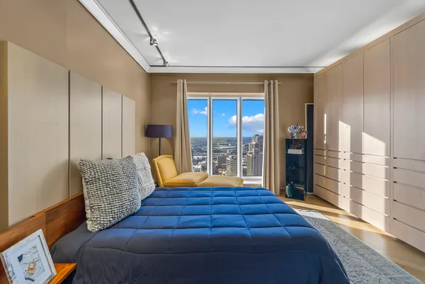 a bedroom with furniture and large windows