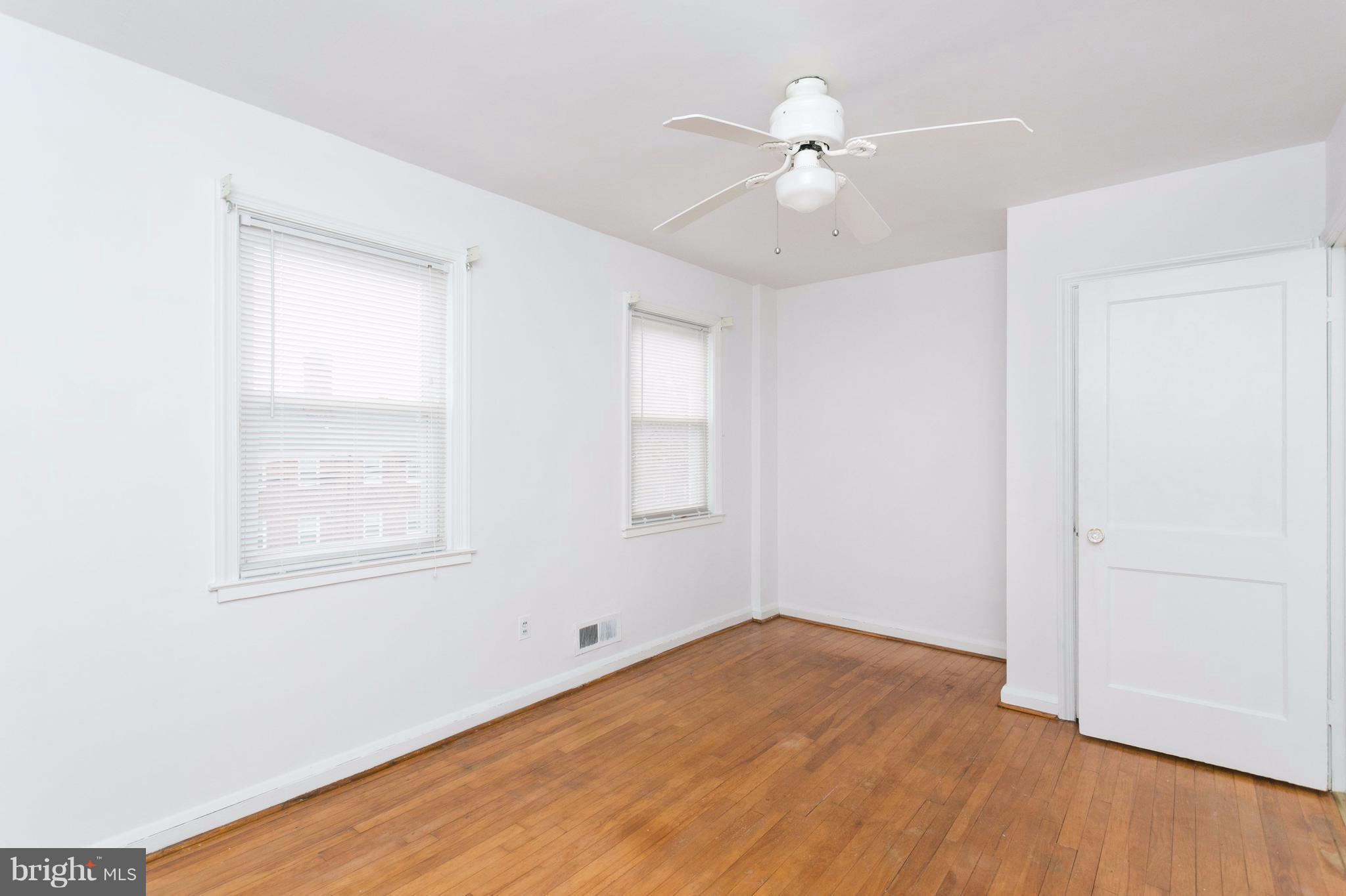 8332 Hillendale Road Baltimore, MD 21234 - Photo 14 of 30 an empty room with wooden floor fan and windows
