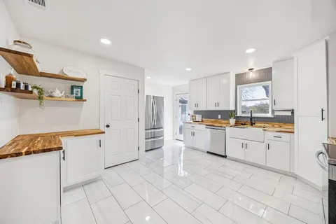 a kitchen with white cabinets and white appliances