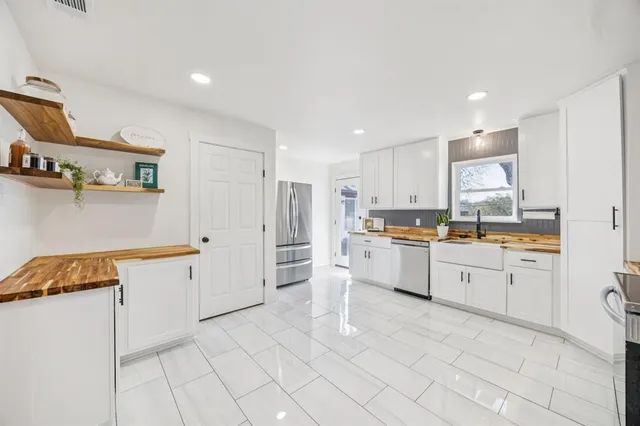 a kitchen with white cabinets and white appliances