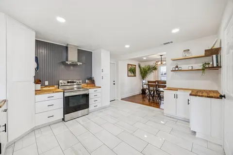 a large white kitchen with cabinets