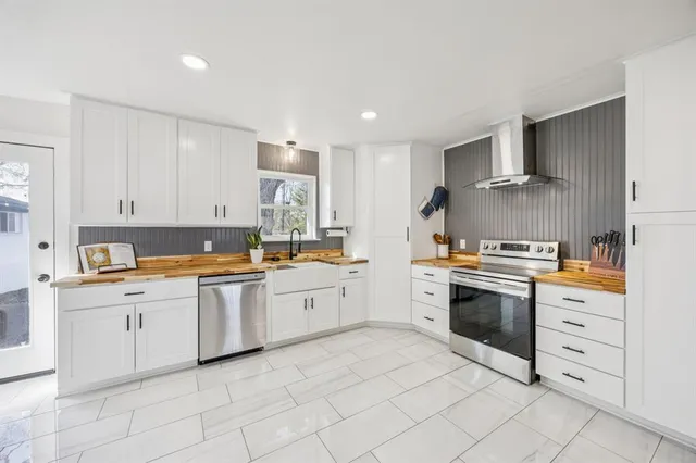 a kitchen with granite countertop white cabinets and white stainless steel appliances