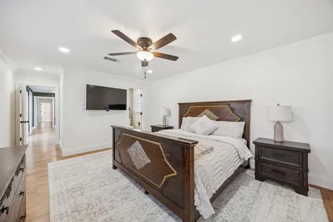 a spacious bedroom with a bed and a flat screen tv