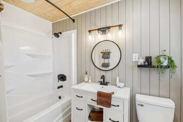 a bathroom with a toilet sink vanity tub and shower