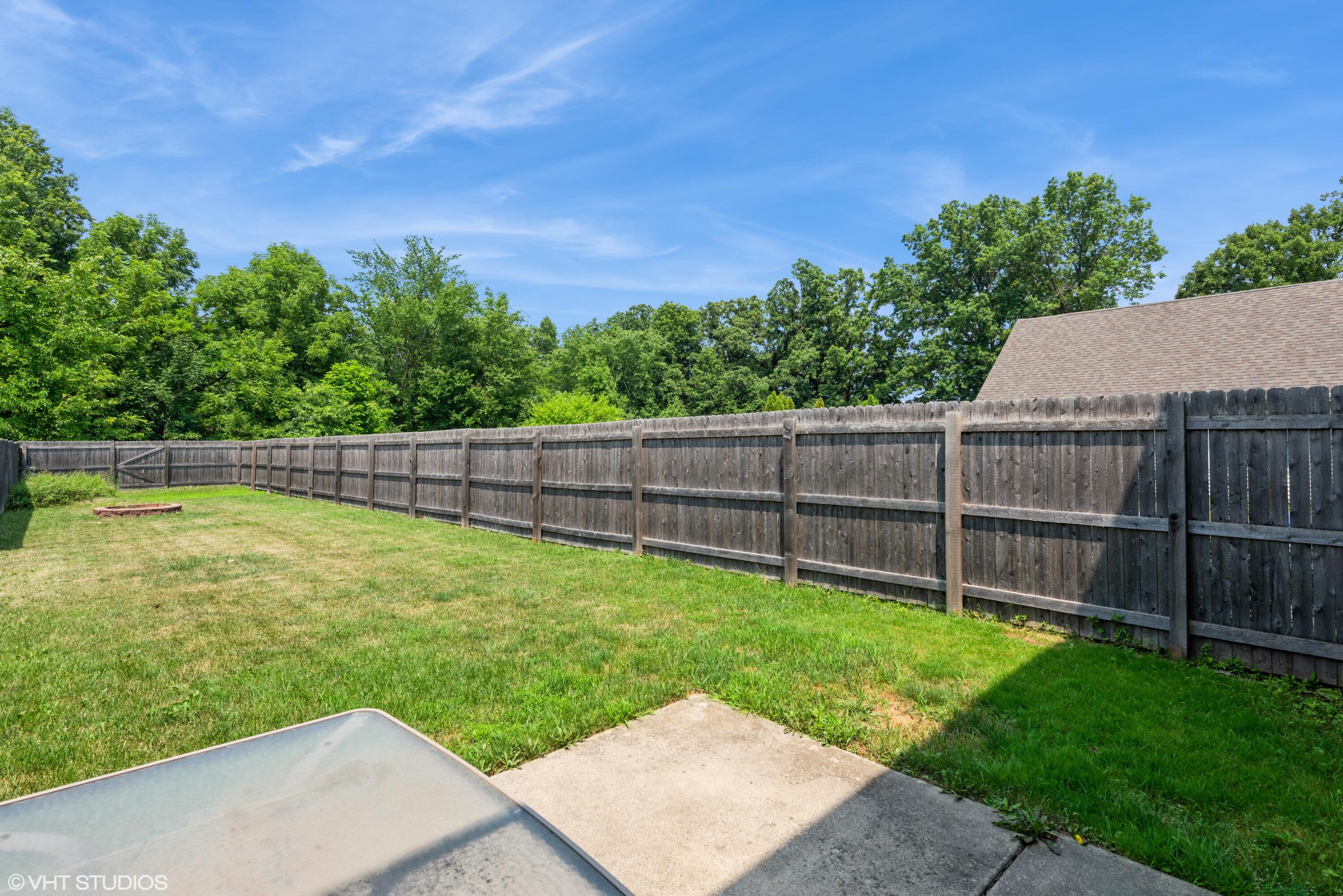 353 South Boo Road, Unit B Burns Harbor, IN 46304 - Photo 11 of 12 a view of a backyard with a tree and wooden fence
