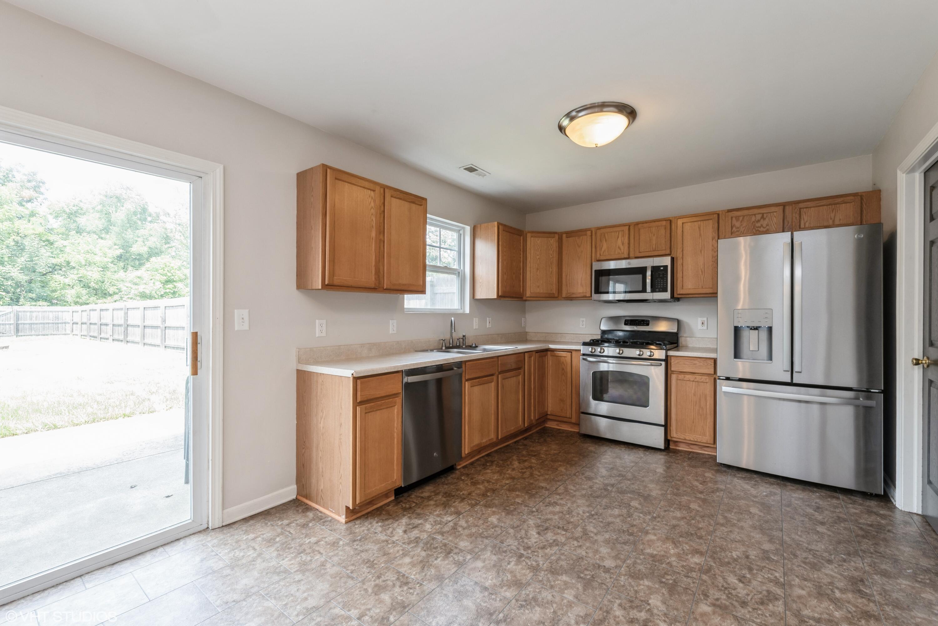 353 South Boo Road, Unit B Burns Harbor, IN 46304 - Photo 3 of 12 a kitchen with granite countertop a refrigerator stove top oven and sink