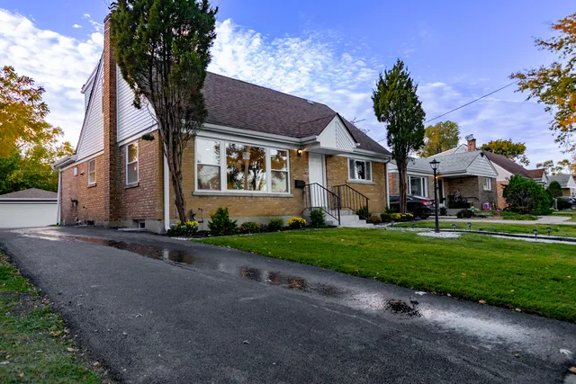 a front view of a house with a yard and outdoor seating