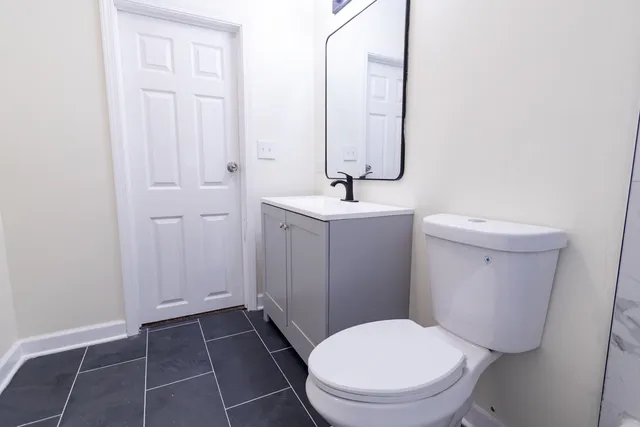 a white toilet sitting next to a bathroom sink