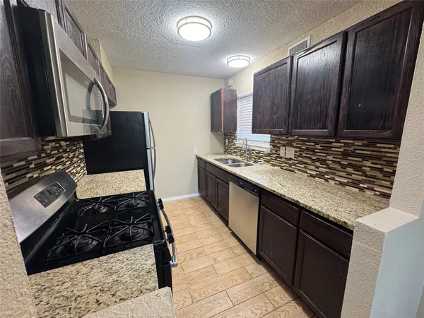 a kitchen with wooden cabinets and a stove top oven