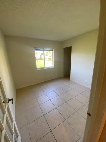 a front view of house with yard and trees in the background