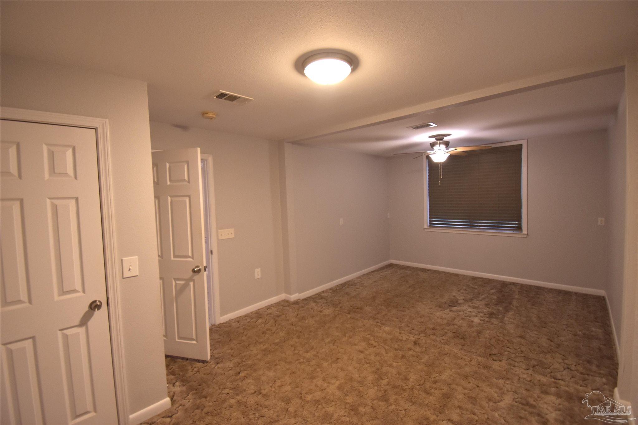 7195 Heath Road Milton, FL 32570 - Photo 15 of 33 a view of an empty room with a chandelier fan