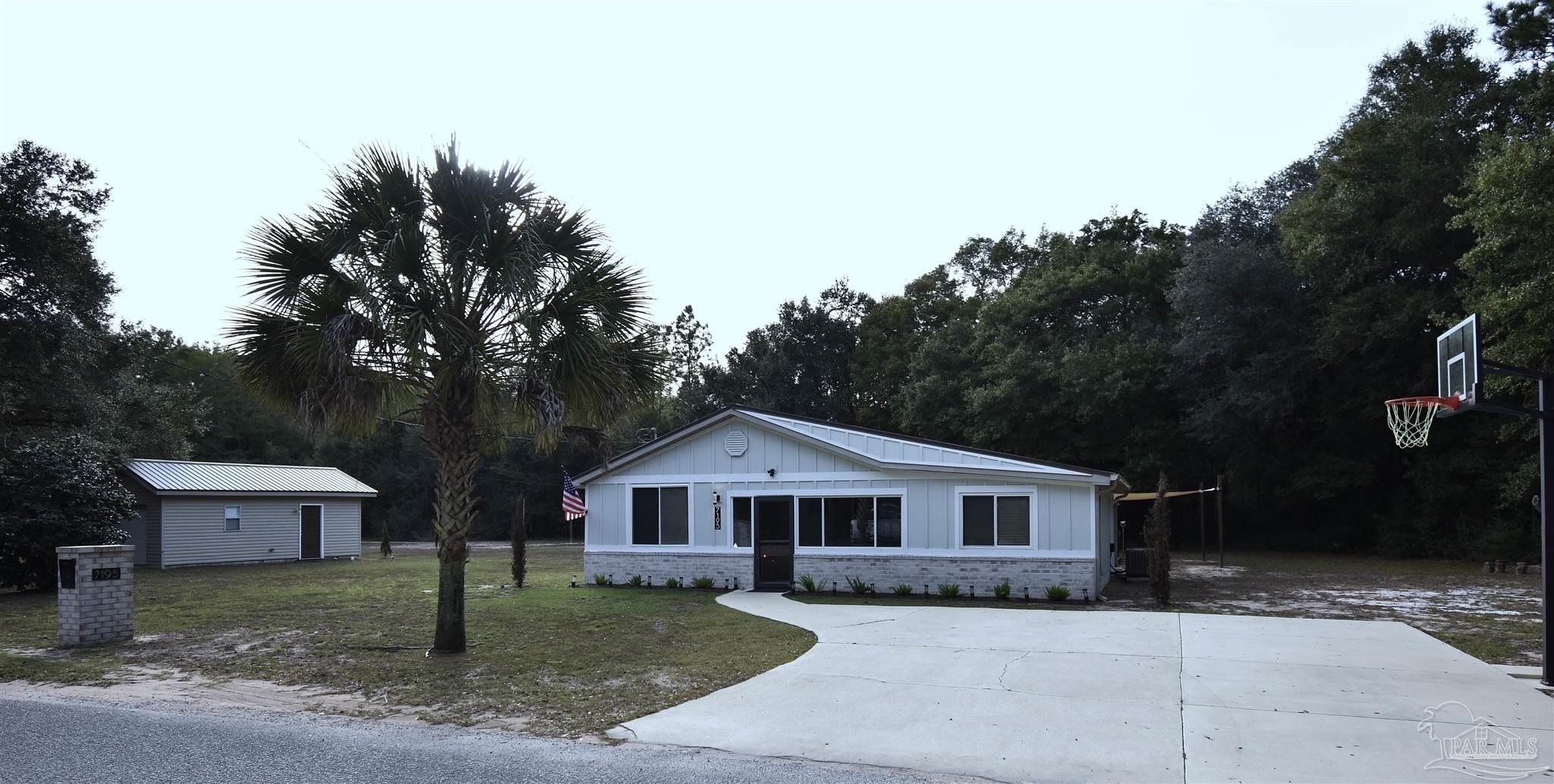 7195 Heath Road Milton, FL 32570 - Photo 2 of 33 a front view of a house with garden