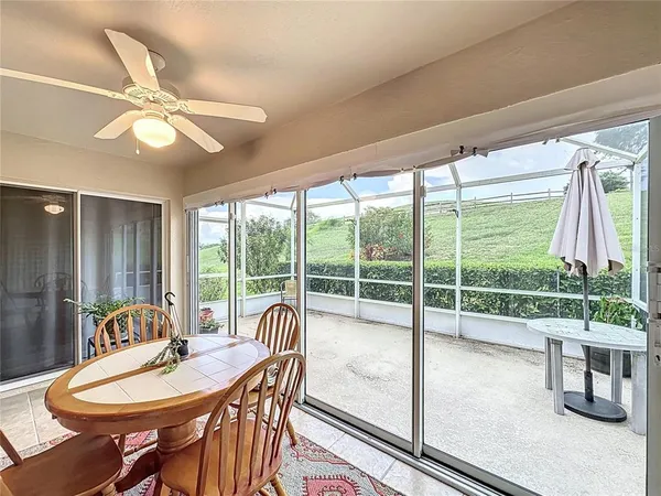 a large white kitchen with a large window a sink dishwasher a dining table and chairs with wooden floor