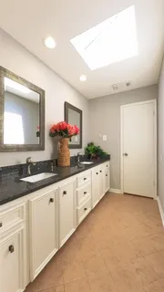 a kitchen with granite countertop white cabinets and white appliances