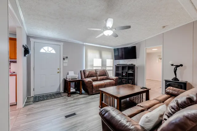 a living room with furniture and a wooden floor