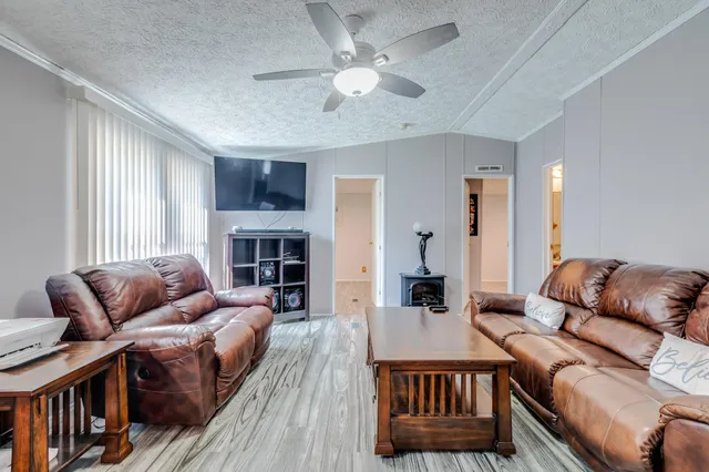 a living room with furniture a fireplace and a window