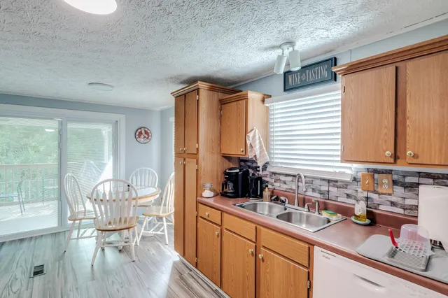 a kitchen with granite countertop a dining table chairs and a large window