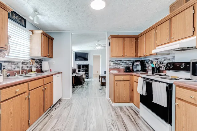 a kitchen with stainless steel appliances granite countertop wooden cabinets a sink and a stove