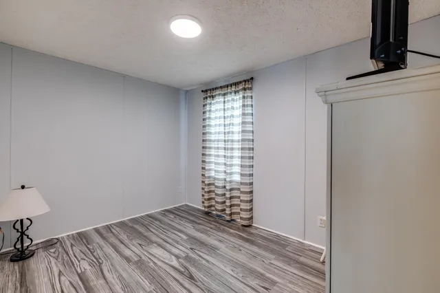 a view of empty room with a fireplace and wooden floor