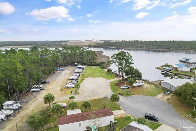 an aerial view of a house with outdoor space and lake view in back