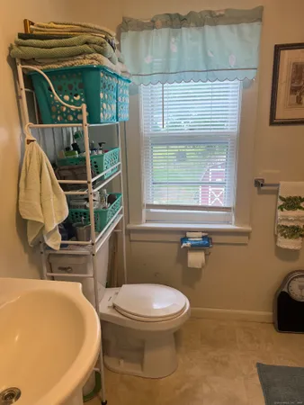 a bathroom with a sink a toilet and a window