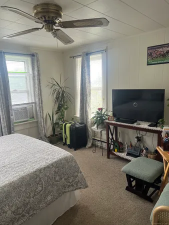 a bedroom with furniture and a flat screen tv