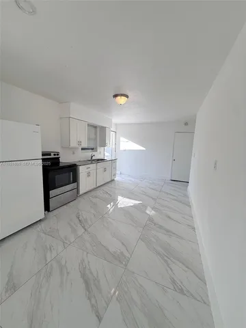 a kitchen with refrigerator and cabinets