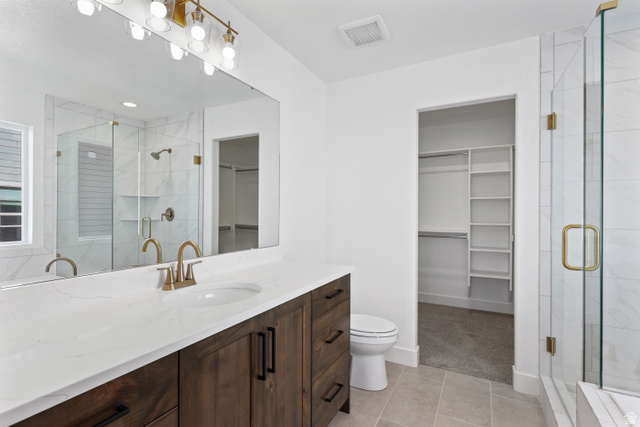 1139 South 4475 West West Point, UT 84015 - Photo 18 of 33 Full bathroom with a walk in closet, vanity, light tile patterned floors, and a shower stall