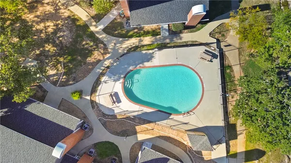 an aerial view of a swimming pool with outdoor seating