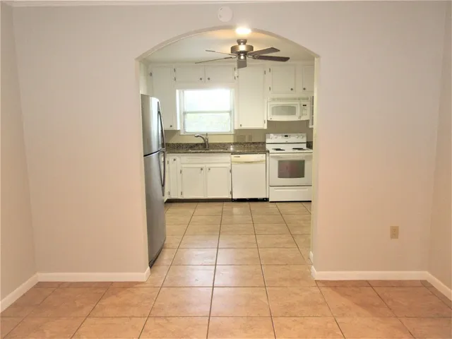 a large white kitchen with a sink and cabinets