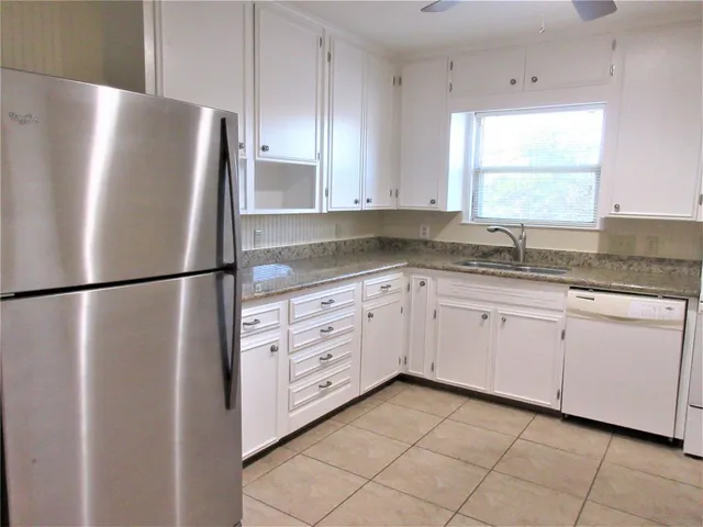 a kitchen with granite countertop cabinets and window