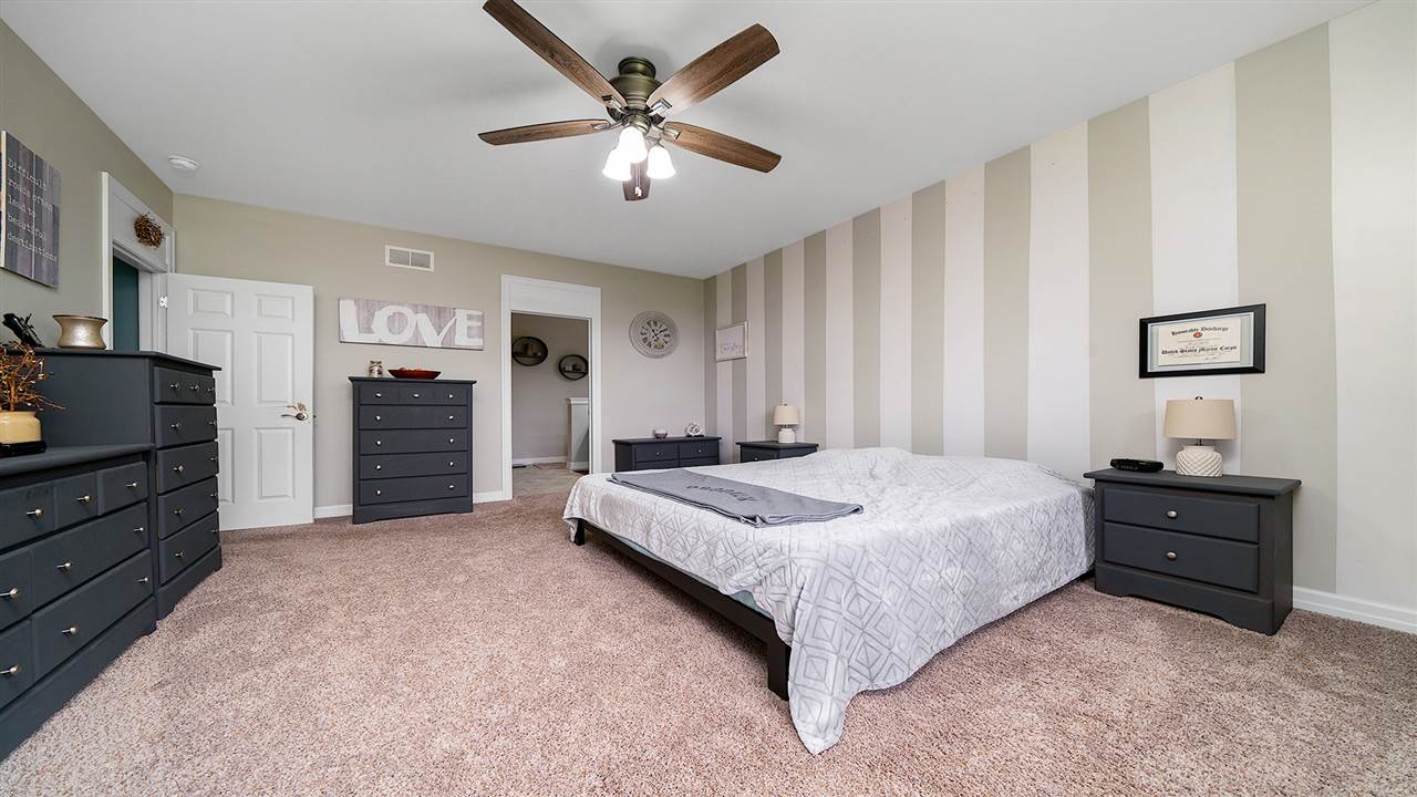 2525 Rogene Drive Oregon, IL 61061 - Photo 20 of 36 a spacious bedroom with a bed and a chandelier