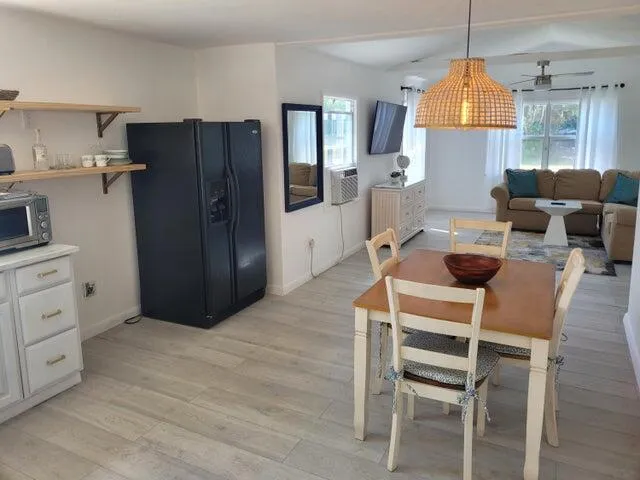 a kitchen with stainless steel appliances a table chairs refrigerator and microwave