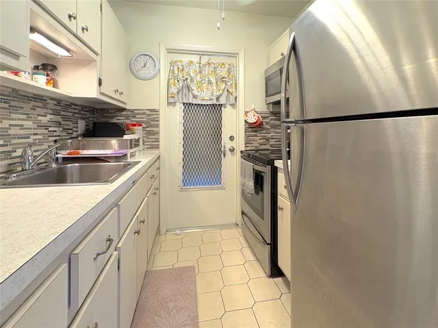 a kitchen with stainless steel appliances granite countertop a refrigerator and a sink