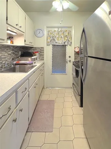 a kitchen with granite countertop white cabinets and stainless steel appliances