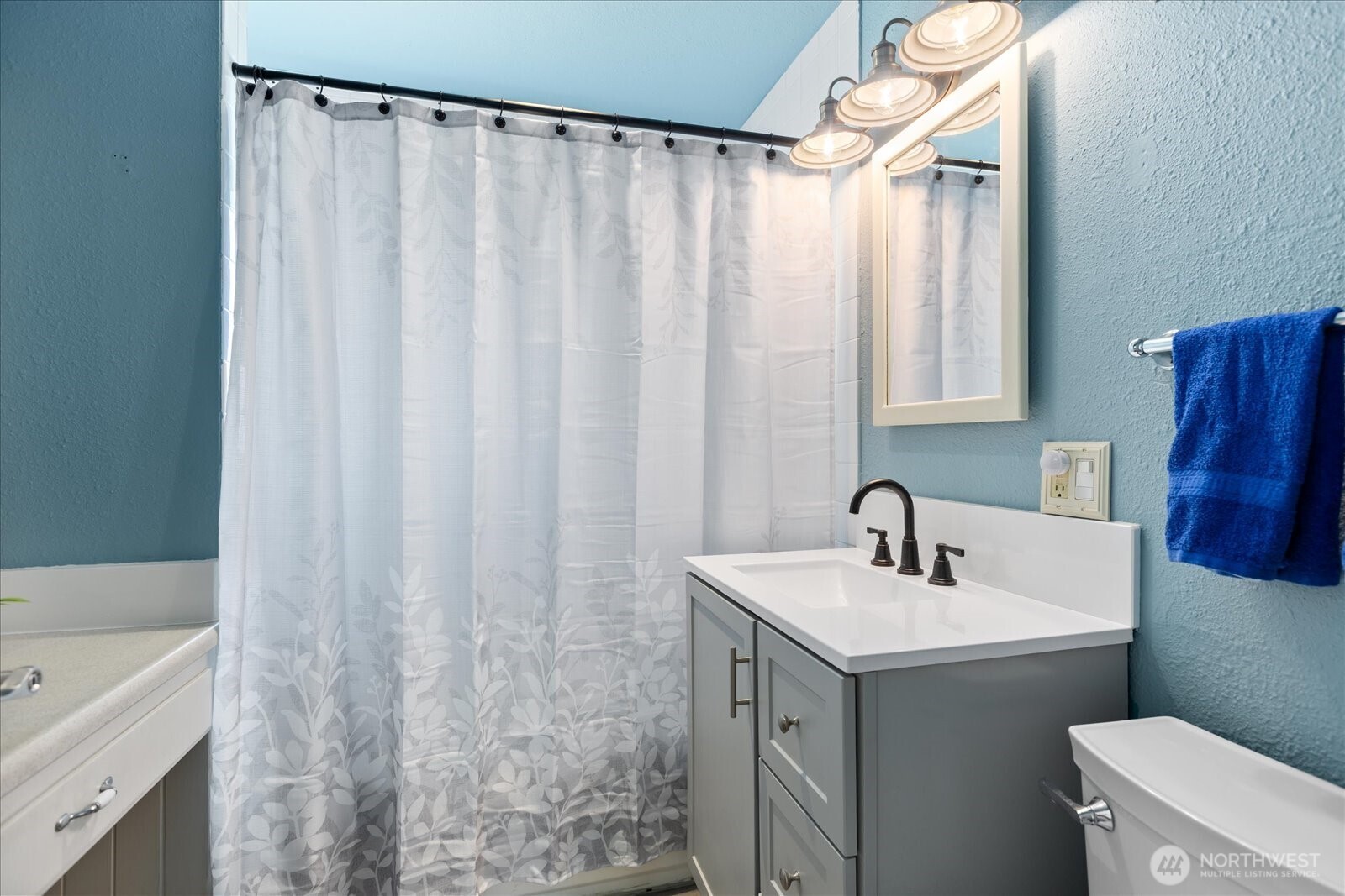 626 Legion Drive Everett, WA 98201 - Photo 23 of 38 a bathroom with a sink a toilet and a mirror