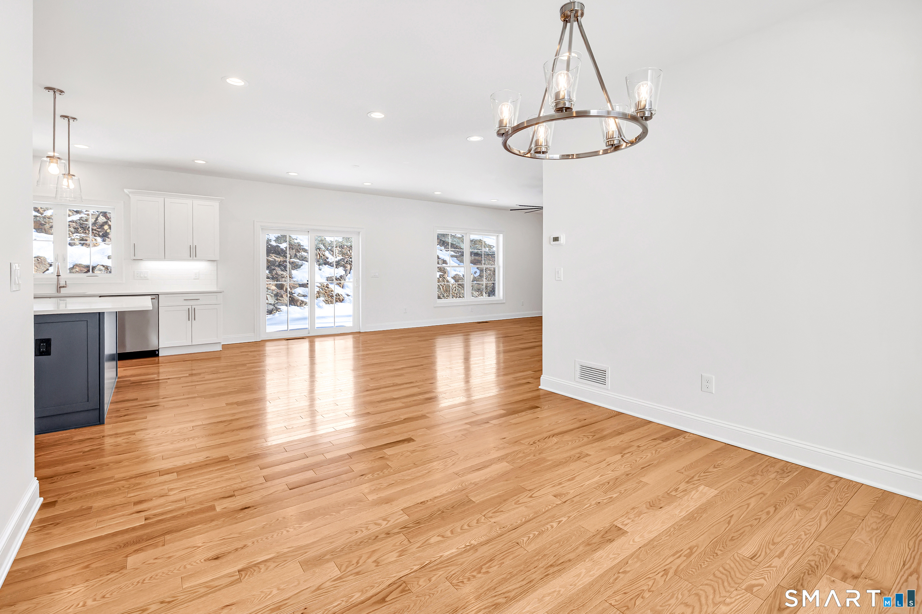 15 Hunting Ridge Road Middlebury, CT 06762 - Photo 16 of 41 a view of a room with wooden floor a chandelier a sink and kitchen view