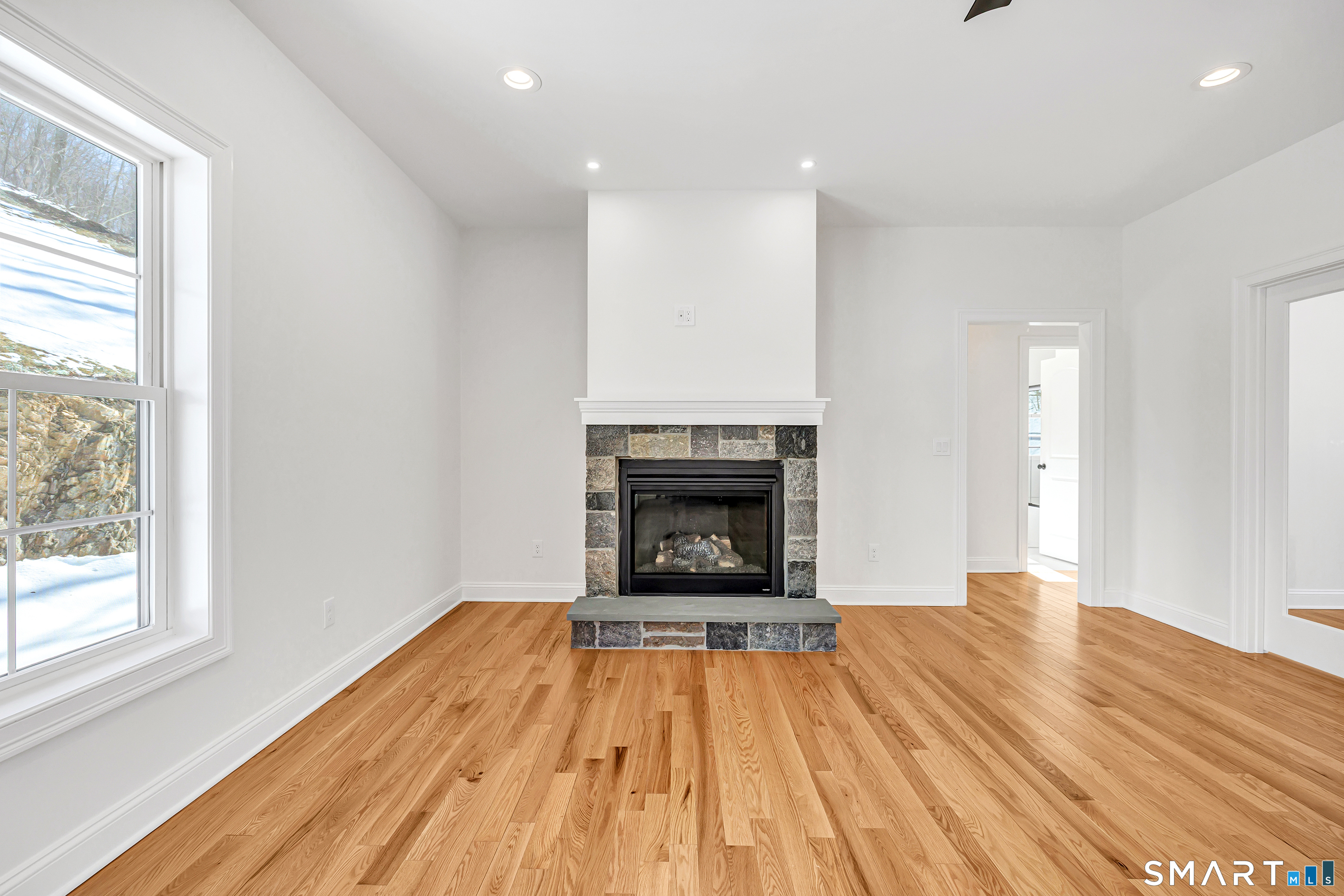 15 Hunting Ridge Road Middlebury, CT 06762 - Photo 9 of 41 a view of empty room with wooden floor and fireplace