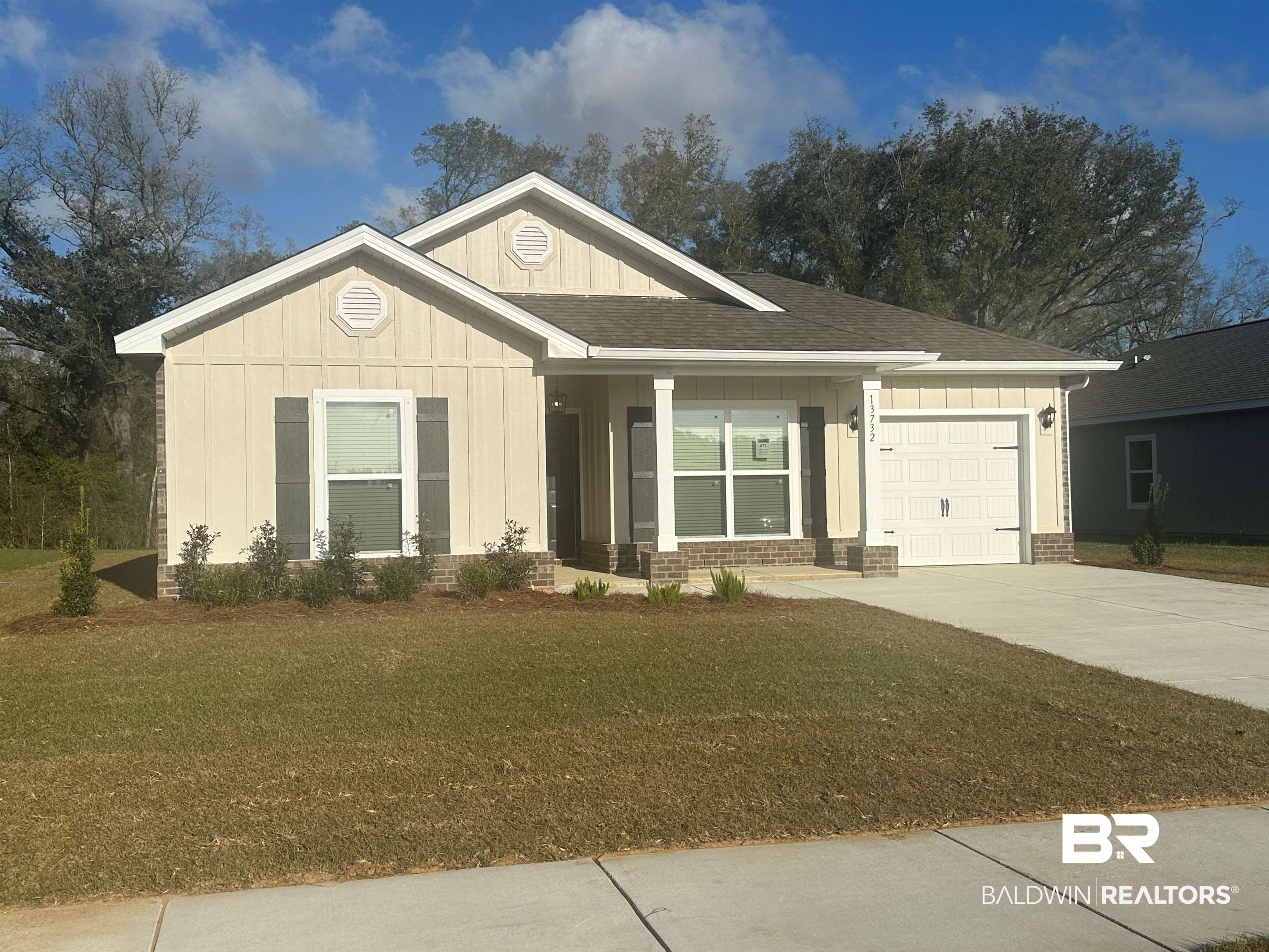 13732 Shea Circle Foley, AL 36535 - Photo 2 of 30 View of front facade featuring a front yard, driveway, roof with shingles, a garage, and board and batten siding