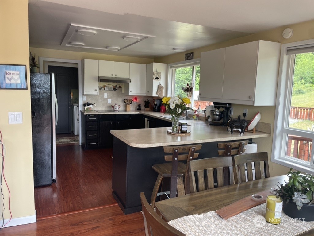 300 Bush Creek Road Elma, WA 98541 - Photo 6 of 21 a kitchen with a table chairs stove and refrigerator
