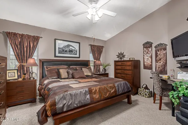 a bedroom with a bed dresser and a chandelier