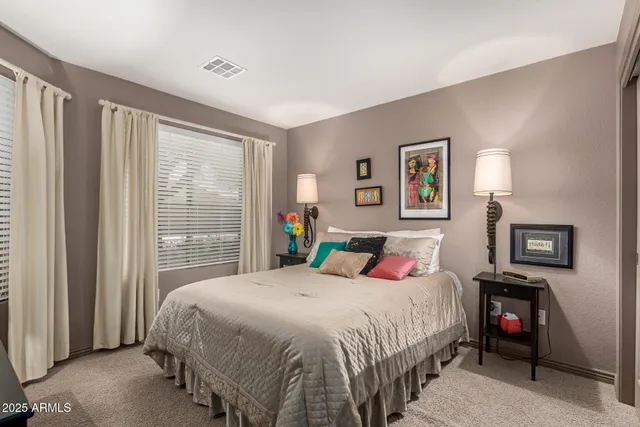 a bedroom with a bed a lamp and a large window