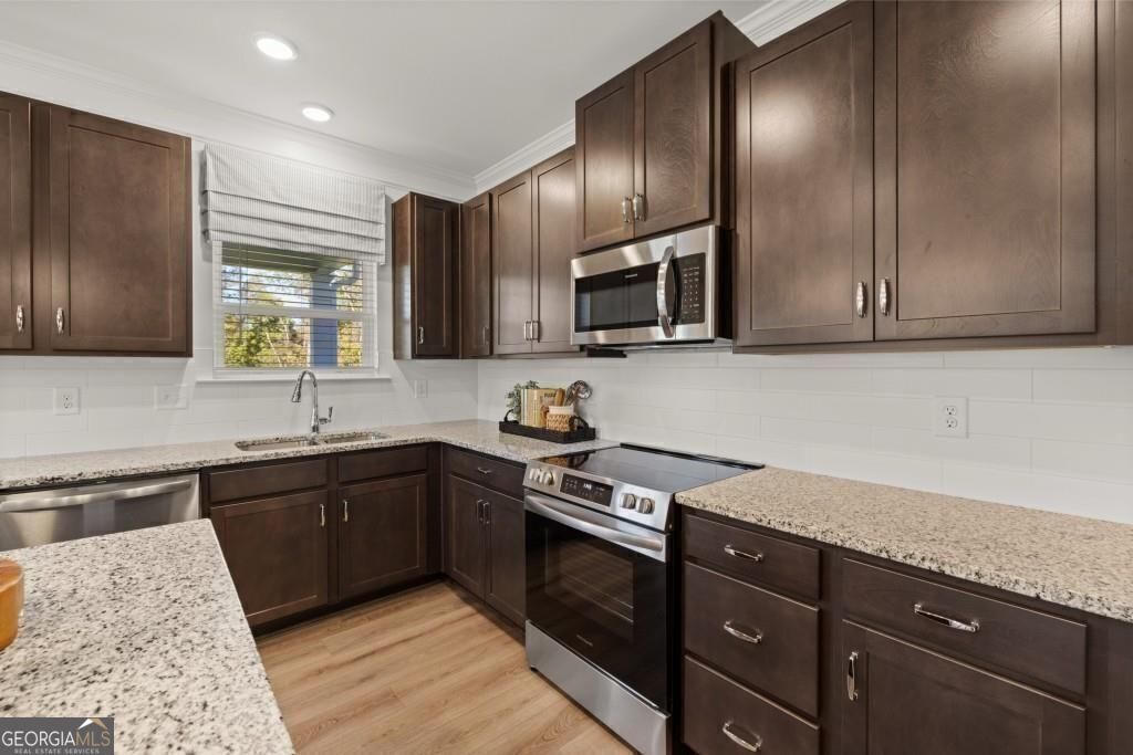 202 Sycamore Lane Calhoun, GA 30701 - Photo 3 of 48 a kitchen with granite countertop wooden cabinets stainless steel appliances and a sink